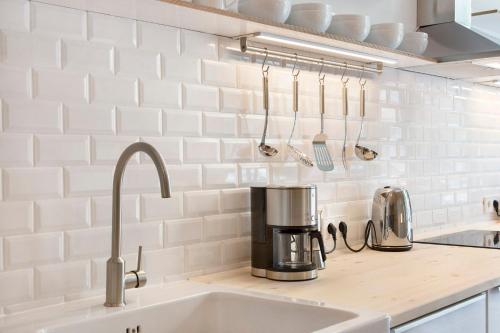 eine Küche mit einer Spüle und einer Kaffeemaschine auf der Theke in der Unterkunft Modern Design Apartment in Berlin