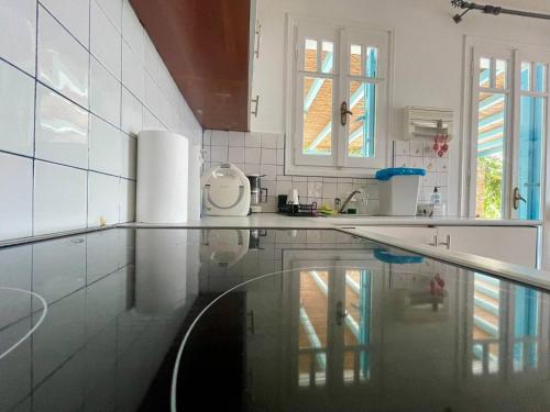 a white kitchen with a sink and a pool in it at Vila Cleopatra Andros Greece in Andros