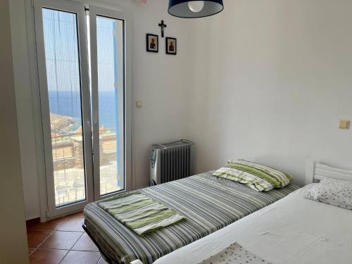 a bedroom with a bed and a cross on the wall at Vila Cleopatra Andros Greece in Andros