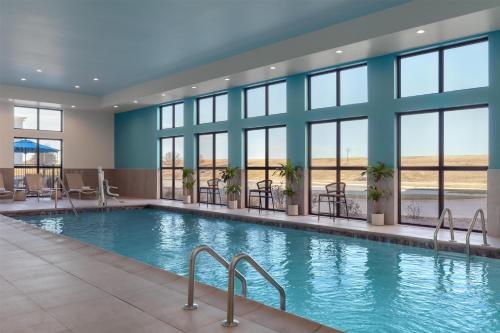 a swimming pool in a hotel lobby with windows at Hilton Garden Inn Wichita Airport in Wichita