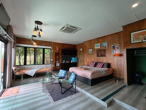 a bedroom with a bed and a living room at Baan Sahai Tone บ้านสหายโทน in Ko Larn