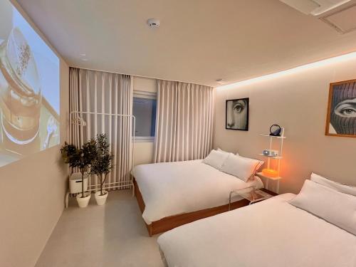 a hotel room with two beds and a window at Stay BUT SEONGSU in Seoul