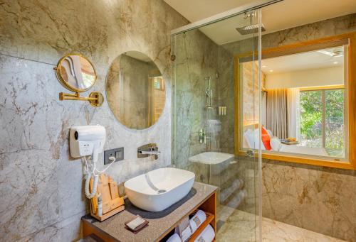 a bathroom with a sink and a shower at The Forest Chapter by Sayaji Sasan Gir in Chitrod