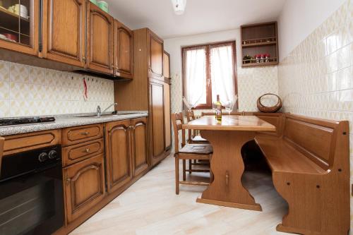 ボルミオにあるAppartamento Da Sergioのキッチン(木製キャビネット、木製テーブル付)