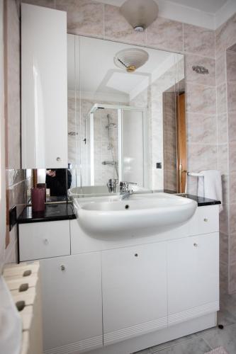 a white bathroom with a sink and a mirror at Appartamento Da Sergio in Bormio