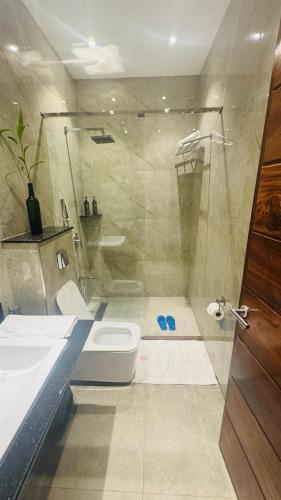 a bathroom with a shower and a toilet and a sink at Millennium Terrace Hotel in Kampala