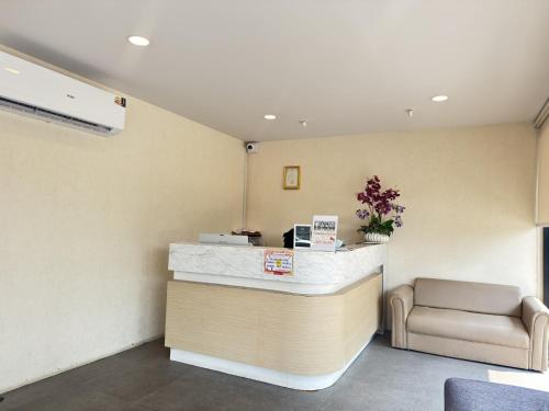 a waiting room with a counter and a chair at One Residence Navanakorn in Pathum Thani