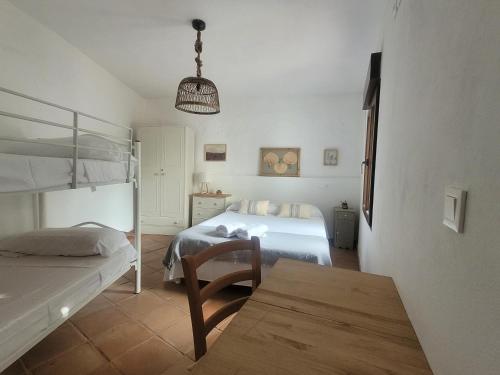a bedroom with two bunk beds and a table at El Corral de la Higuera in Campofrío