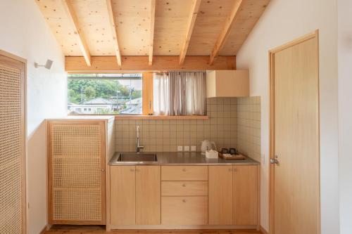a small kitchen with a sink and a window at ホテル聚 - Hotel SHU in Tonosho