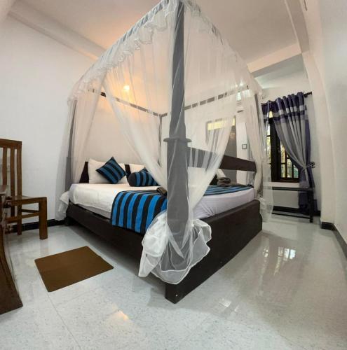 a bedroom with a bed with a mosquito net at Sigiriya Danu Homestay in Sigiriya