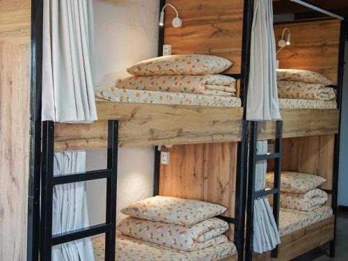 a wooden bunk bed with pillows on it at Dolon Hostel in Bishkek