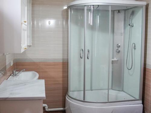 a bathroom with a shower and a toilet and a sink at Dolon Hostel in Bishkek