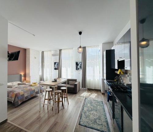 a room with a bed and a kitchen with a table at Sunny Studio Apartment in Iaşi