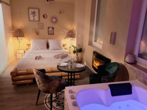 a bedroom with a bed and a fireplace and a tub at L'instant d'évasion Vue mer in Lampaul-Plouarzel