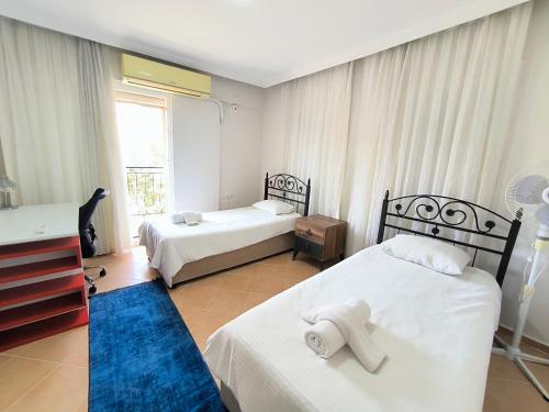 a hotel room with two beds and a window at Villa Elma in Kuşadası