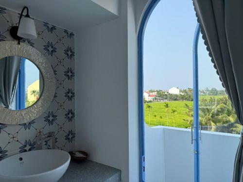 a bathroom with a sink and a mirror and a window at Laco Villa in Danang