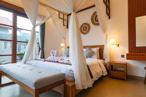 a bedroom with a canopy bed with a window at Pondok Naya Ubud in Ubud