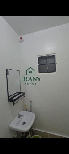 a bathroom with a white sink and a window at JRAN's Place Home in Baliuag, Bulacan in Suliban