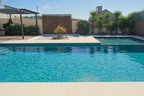 a swimming pool with blue water in a yard at OLA Guesthouse in Esmoriz