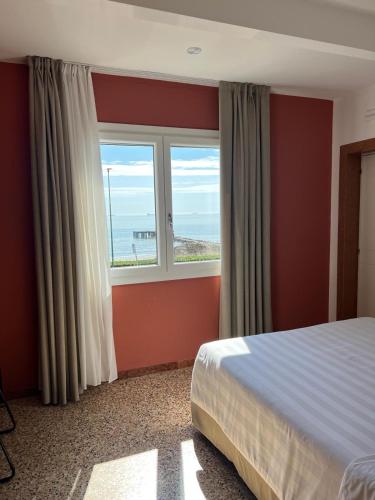 a bedroom with a bed and a window with the ocean at Sea Tower Torre Telemetrica Lido di Venezia in Venice-Lido