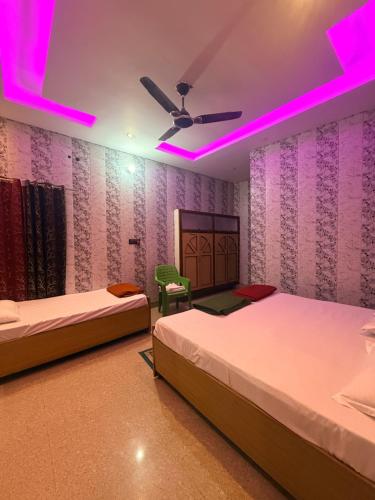 two beds in a room with purple lights at Vijay palace 850 meter away from Ram mandir in Ayodhya