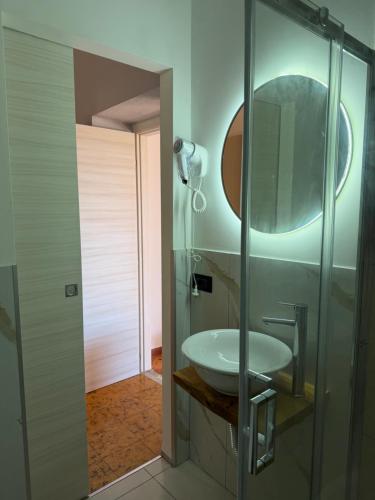 a bathroom with a sink and a glass shower at Neverland Deluxe in Santa Maria