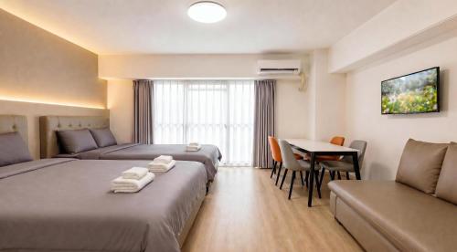 a hotel room with two beds and a table at Lucky NAMBA 大阪難波 なんば in Osaka