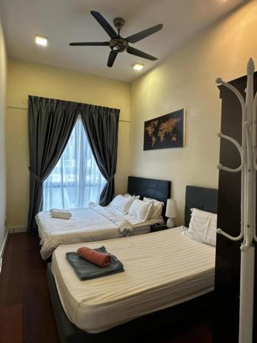 two beds in a room with a ceiling fan at VH HOMES l Imago Mall l 2BR Family Suite l Garden Direct Access in Kota Kinabalu