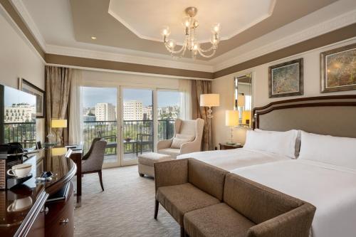 a hotel room with a bed and a chandelier at Waldorf Astoria Jerusalem in Jerusalem