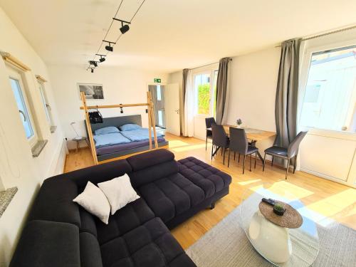 a living room with a couch and a bedroom at Apartment am Rohrbach in Friedrichshafen