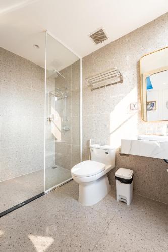 a bathroom with a toilet and a shower and a sink at HUB MULTI 3 HOTEL - Sea & Firework View in Phú Quốc