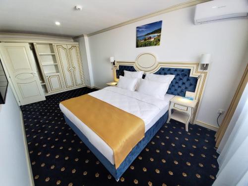 a hotel room with a large bed and a chair at Hotel Terra in Neptun