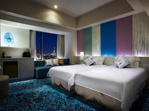 ein Schlafzimmer mit einem großen Bett und einer Couch in der Unterkunft Hotel Universal Port in Osaka