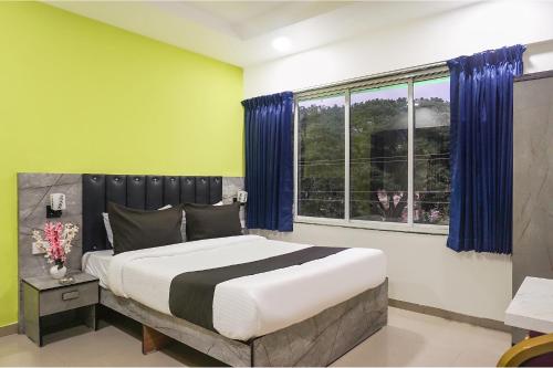 a bedroom with a large bed and a window at FabHotel Vardhan Plaza in Pune
