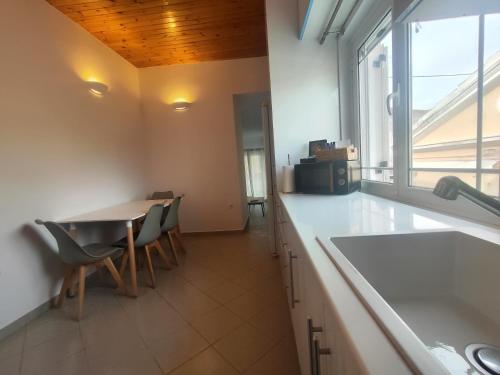 a kitchen with a sink and a table with chairs at Piazza di Lefkimmi in Lefkimmi
