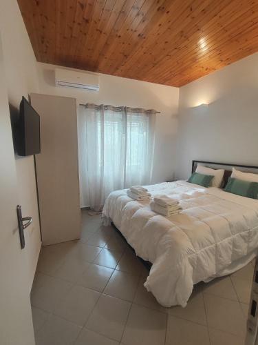 a bedroom with a large bed with a wooden ceiling at Piazza di Lefkimmi in Lefkimmi