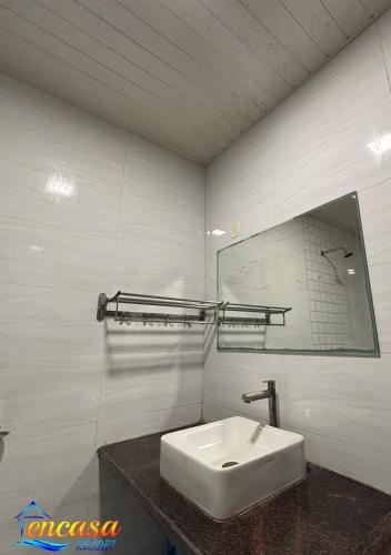 a bathroom with a white sink and a mirror at Encasa Resort in Nagaon