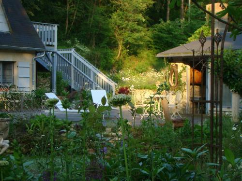 a garden with white chairs and a house at Le jardin de Saint Jean in Saint-Jean-aux-Bois