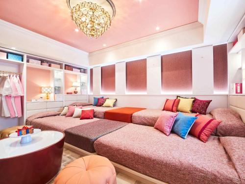 ein Zimmer mit zwei Betten und bunten Kissen in der Unterkunft Hotel Universal Port in Osaka