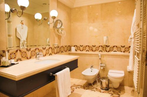 a bathroom with a sink and a toilet and a mirror at Warwick Palm Beach Hotel in Beirut