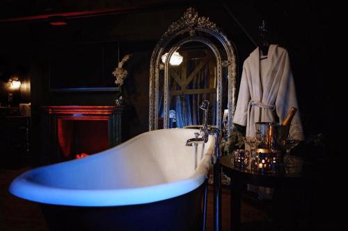a bathroom with a white tub and a mirror at Domaine 10 in Schore