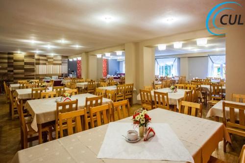 a dining room with tables and chairs with flowers on them at Ośrodek Wypoczynkowy Olimp in Szklarska Poręba