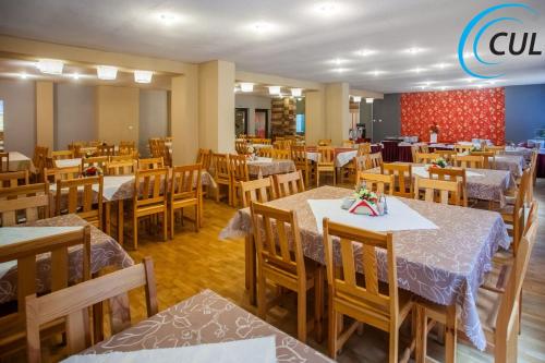 a restaurant with wooden tables and wooden chairs at Ośrodek Wypoczynkowy Olimp in Szklarska Poręba