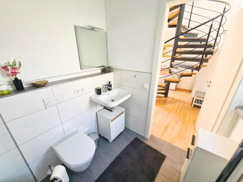a bathroom with a toilet and a sink and a staircase at Apartment am Rohrbach in Friedrichshafen
