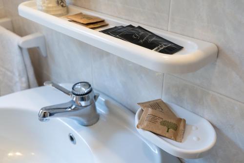 a bathroom with a sink with a book on it at Albergo Alla Costa in Ledro