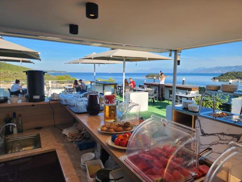 a counter with food on it with a view of the ocean at Ventus Hotel in Ksamil
