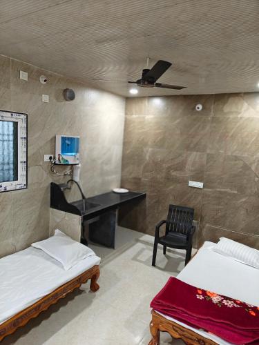 a bedroom with two beds and a desk and a chair at Vasavi Homes in Mādhavaram