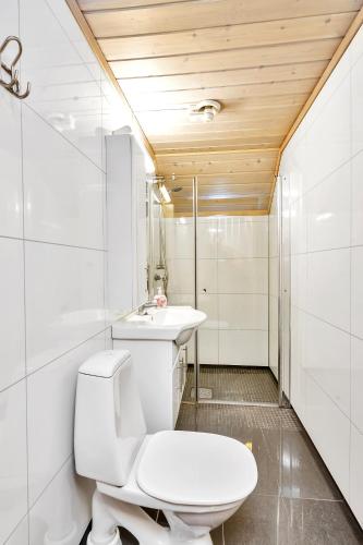 a white bathroom with a toilet and a sink at Skottevik Feriesenter in Skottevik