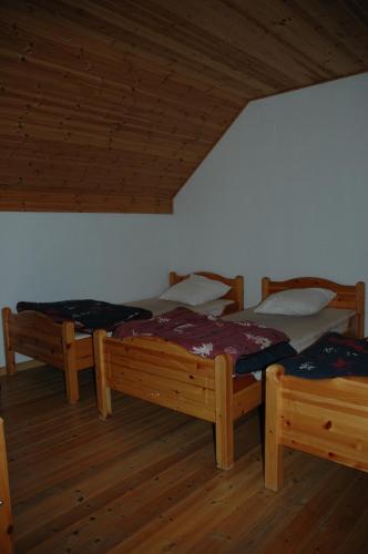 a room with three beds and a wooden ceiling at Le Domaine Appartements in Bilstain