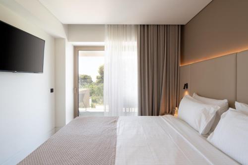 a hotel room with a bed and a television at Vincci EverEden in Anavyssos